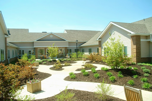 A beautifully landscaped building with pathways and greenery in a sunny environment.
