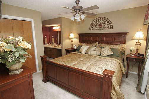 A cozy bedroom with a large wooden bed and elegant decor.