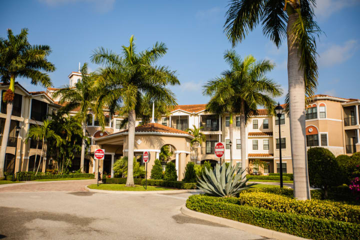 A luxurious tropical resort with palm trees and beautiful landscaping under a sunny sky.