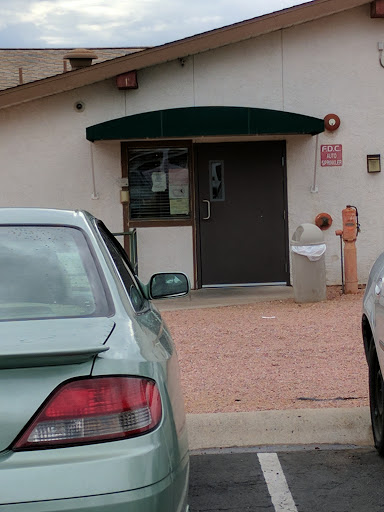 A view of a building entrance with a parked car nearby.