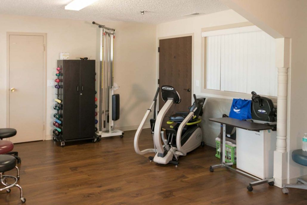 A well-equipped home gym with various workout machines and weights.