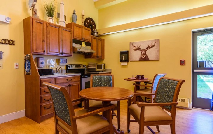 A cozy kitchen and dining area with wooden cabinets, a round table, and chairs.