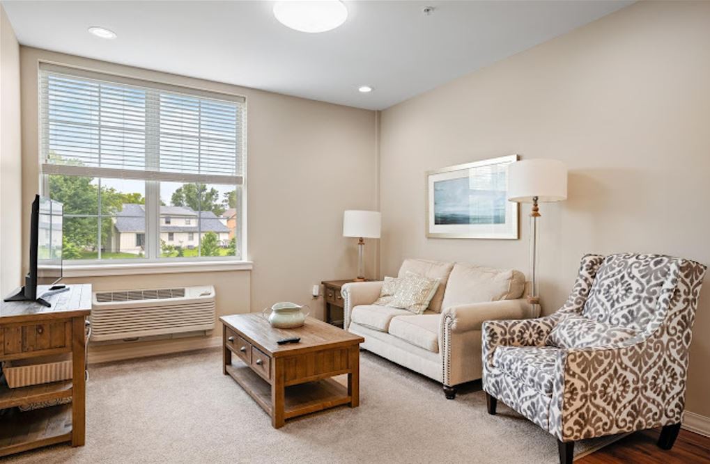 A cozy living room with a sofa, armchair, and coffee table.