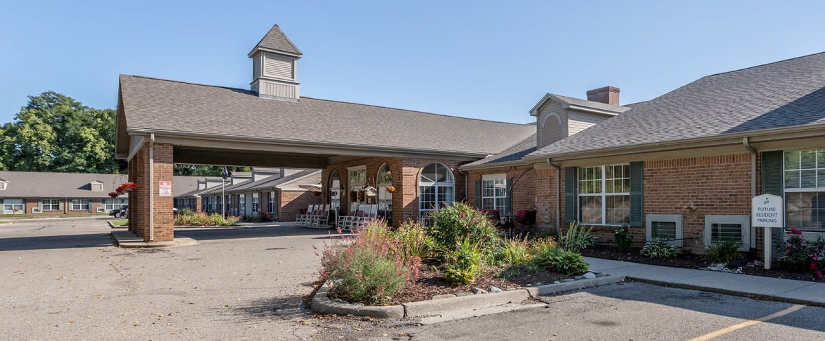 A spacious building with a brick exterior and well-maintained landscaping at its entrance.