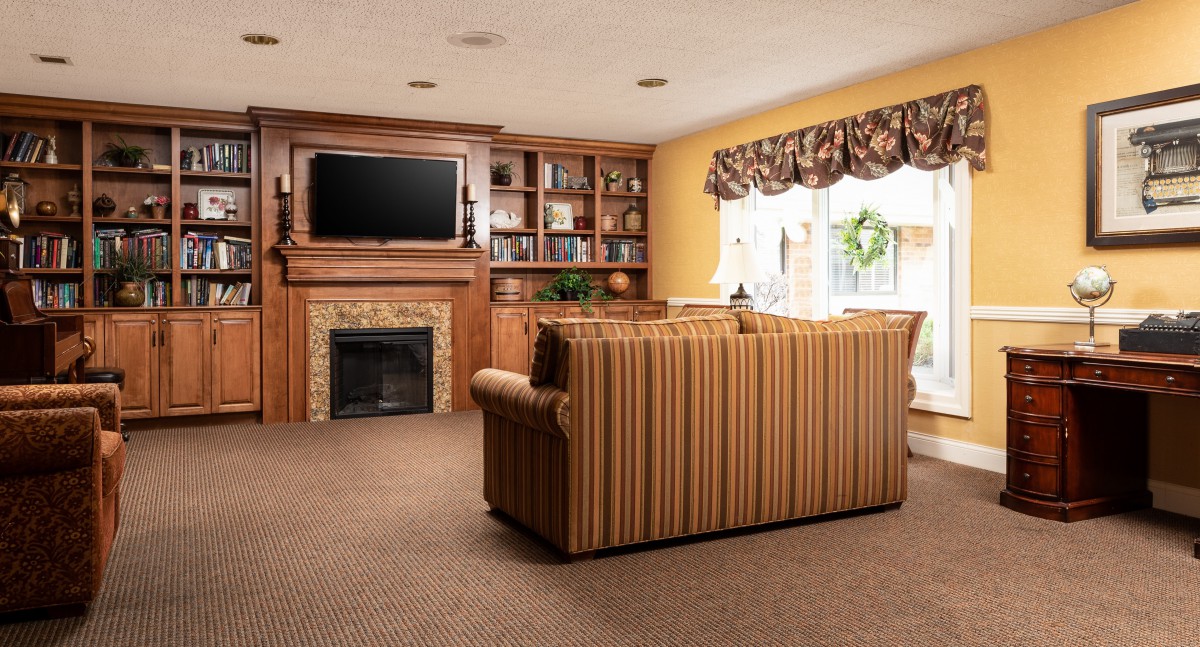 Cozy living room with a couch, fireplace, and television.