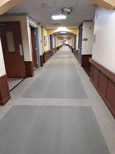 A view of a long hallway with doors on either side and a clean, well-maintained floor.