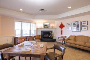 A cozy living room with a fireplace, seating area, and table.