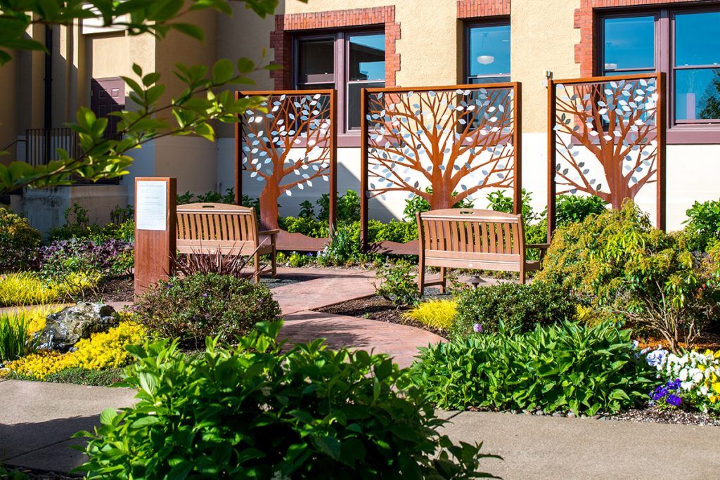 A serene garden setting with wooden benches and decorative tree panels.