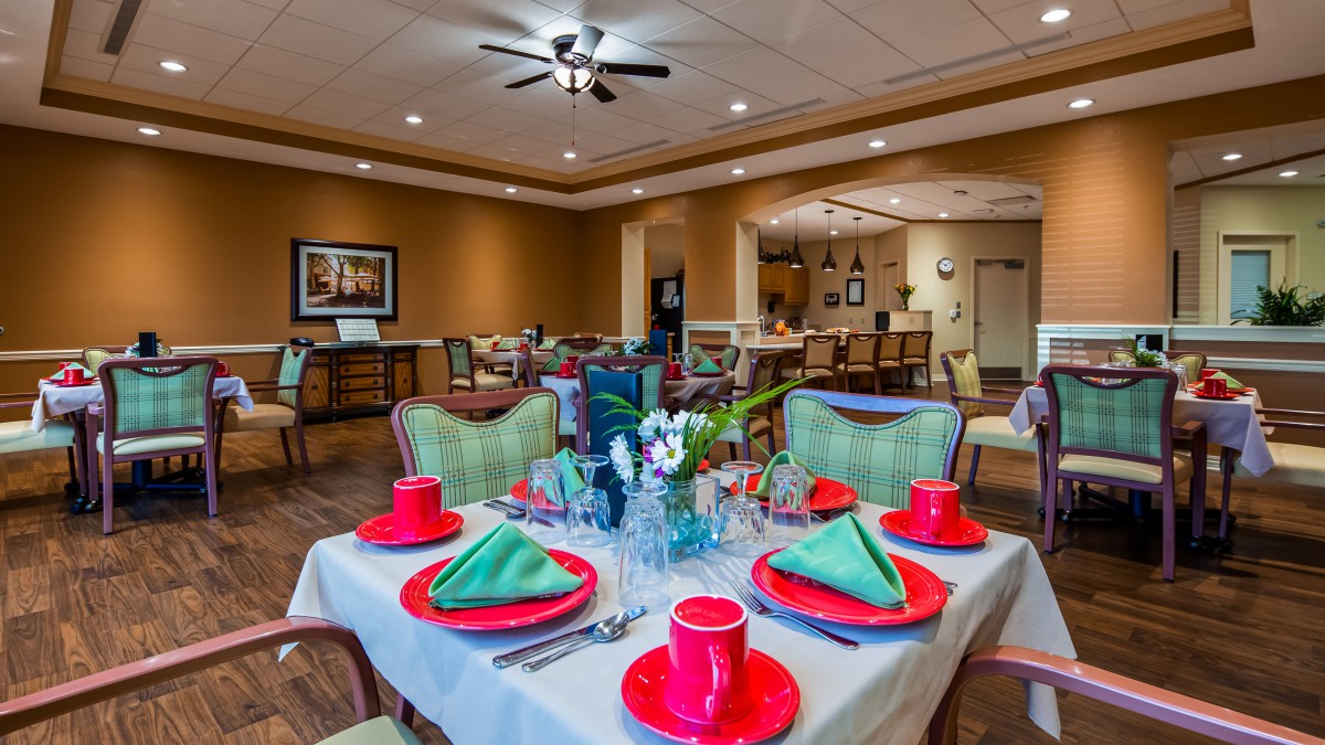 A well-decorated dining area with a neatly set table, featuring red plates and green napkins.