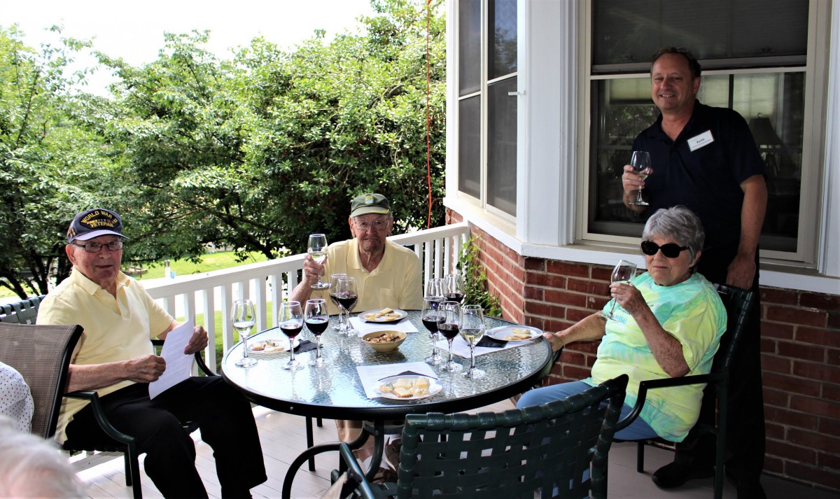 A group of people enjoying wine together on a patio.