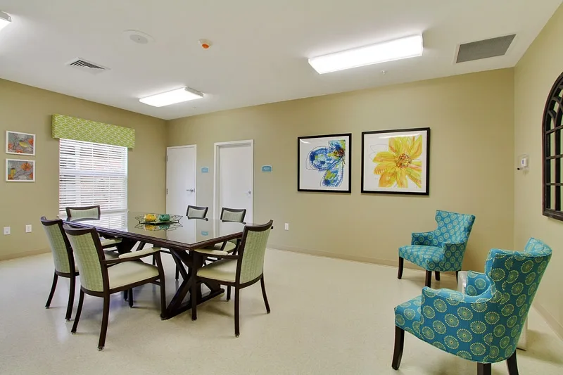 A modern meeting room with a conference table, chairs, and colorful wall art.