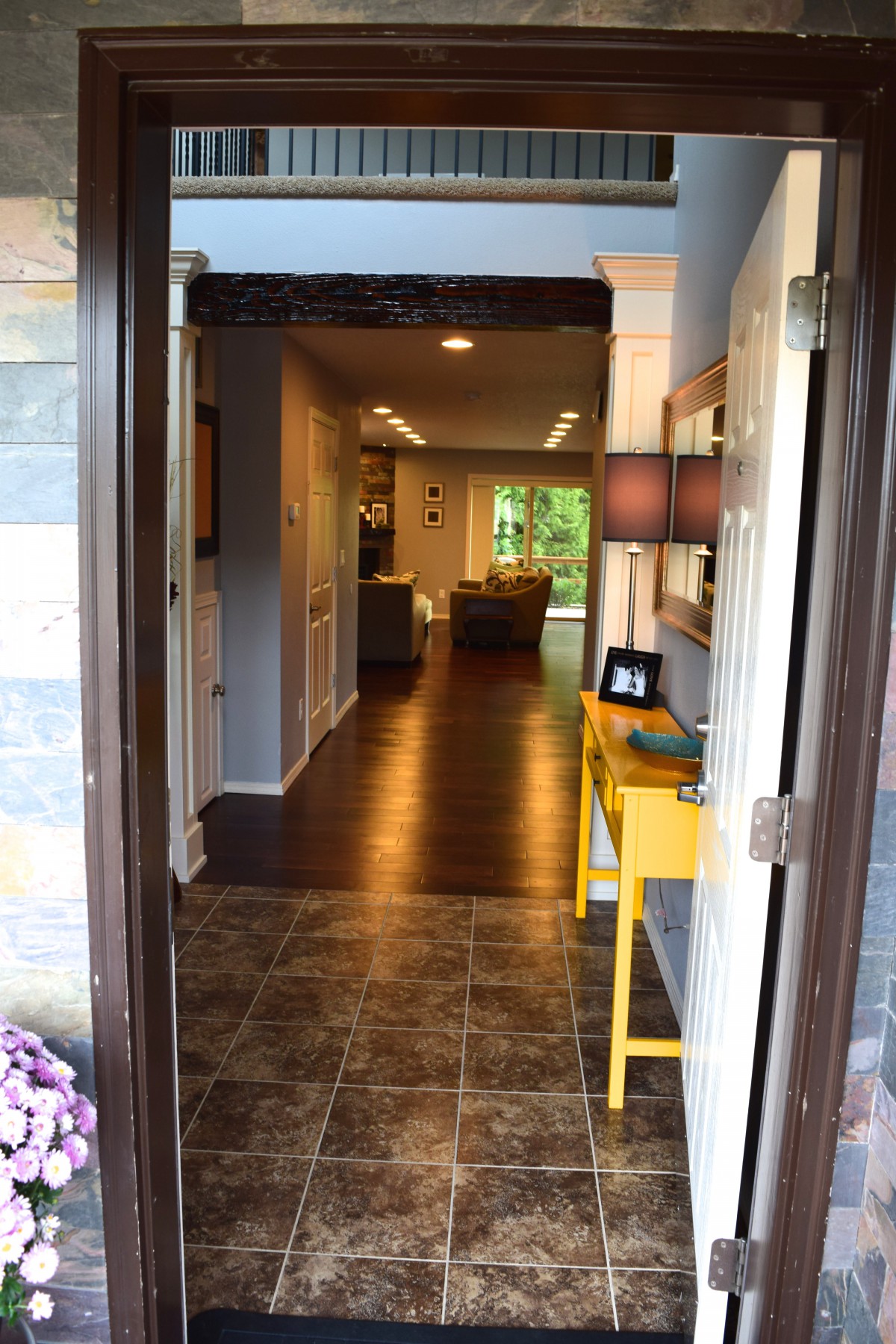 A welcoming view into a cozy home with an open door leading to a hallway and living room area.