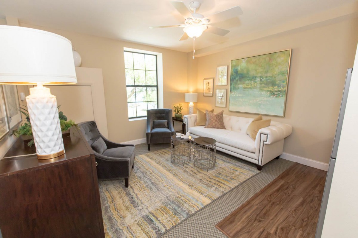 A cozy and well-decorated living room with a sofa, armchairs, and artwork on the walls.
