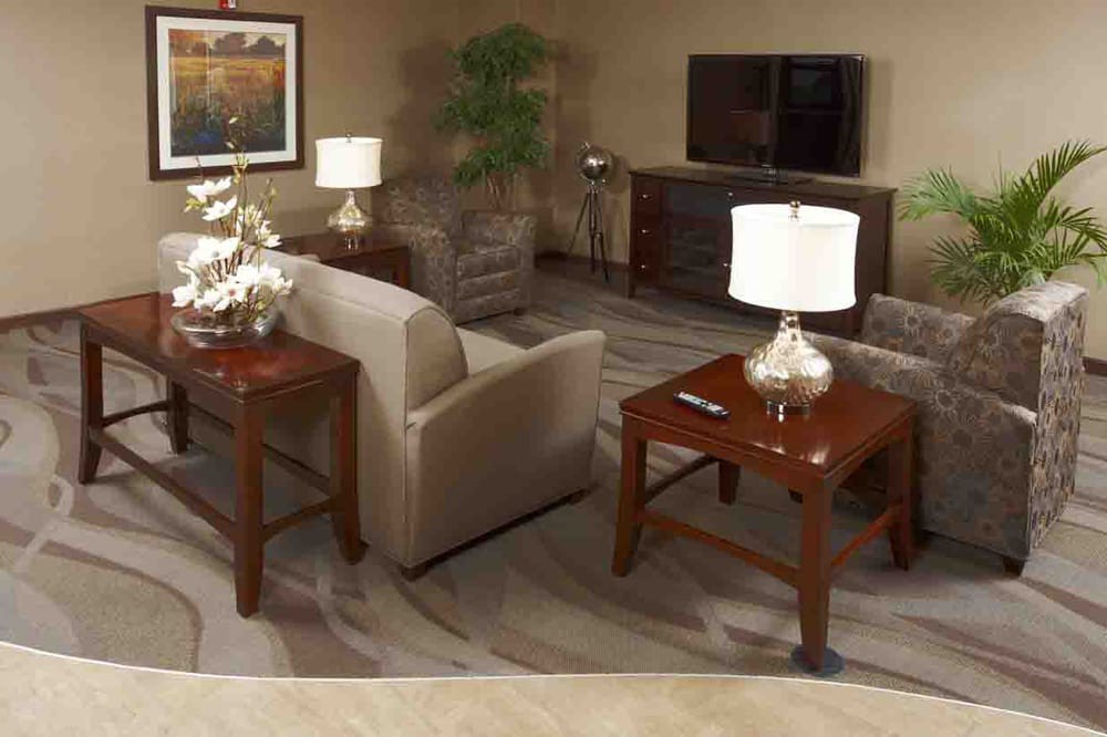 A cozy living room with a sofa, wooden tables, and elegant table lamps.