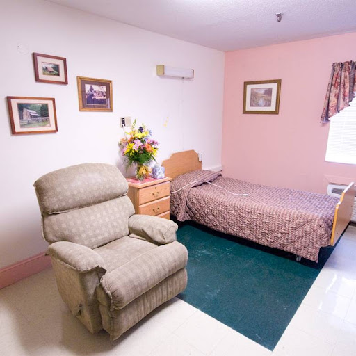 A cozy bedroom featuring a single bed, a comfortable chair, and decorative elements on the walls.