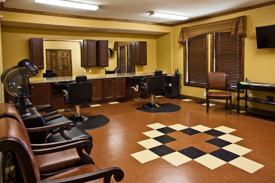 A well-lit salon interior featuring multiple barber chairs, mirrors, and a stylish flooring design.