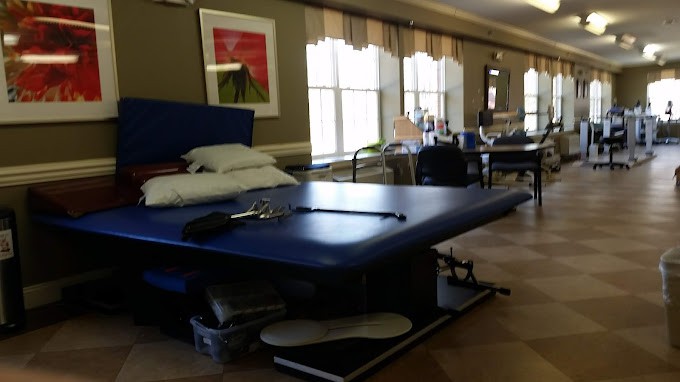 A physical therapy clinic with a treatment table and equipment.