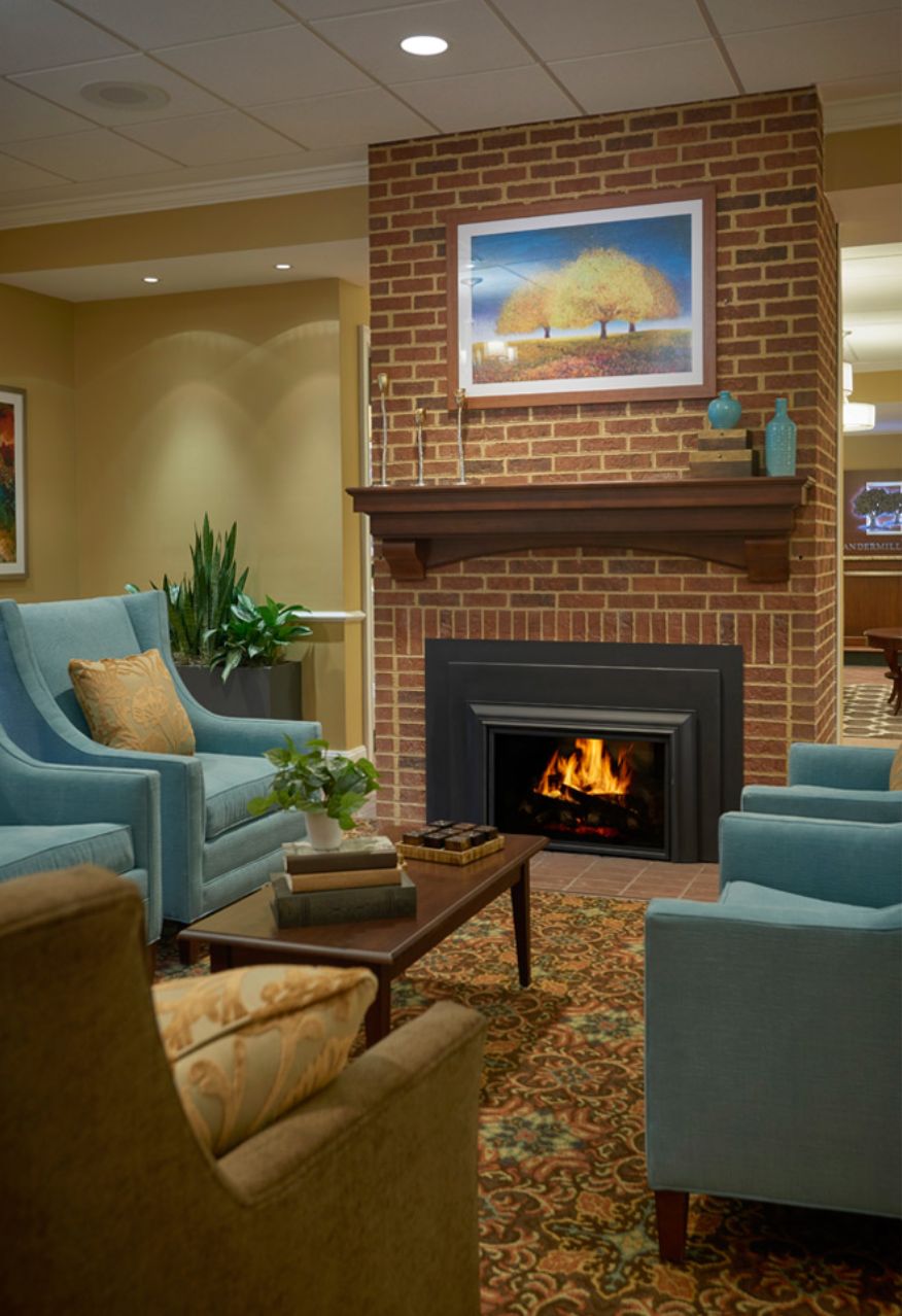 A cozy living room with a brick fireplace and comfortable seating.