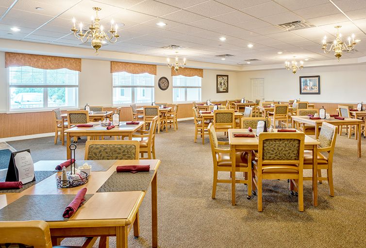 An empty dining room with neatly arranged tables and chairs, ready for service.