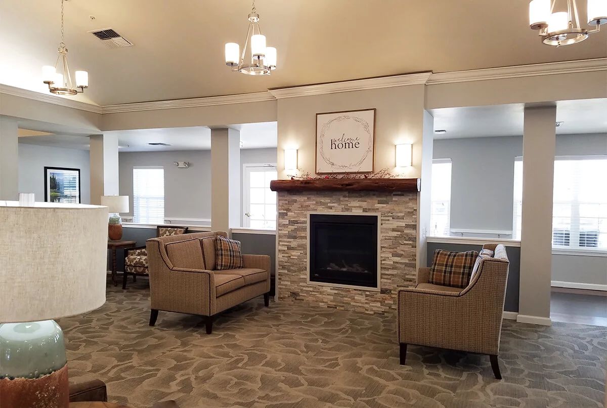 A cozy living room with a stone fireplace and comfortable seating.