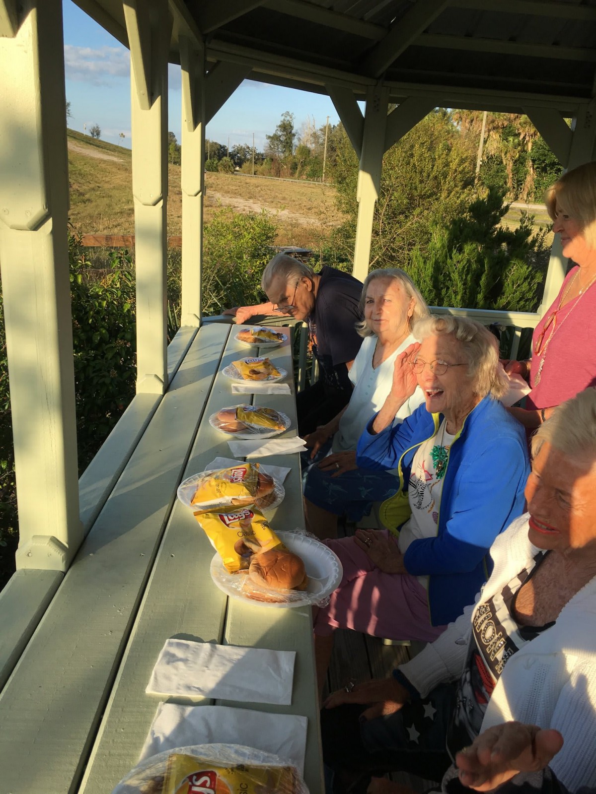 A group of people enjoying a picnic outdoors at sunset.