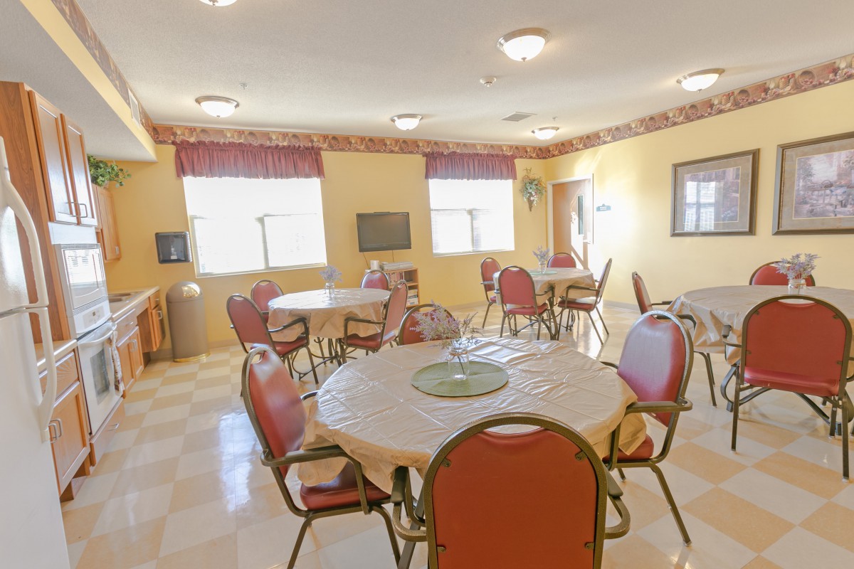 A cozy dining area with multiple round tables and chairs, set in a well-lit room.