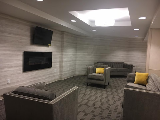 A modern lounge area featuring comfortable seating and televisions, designed for relaxation.