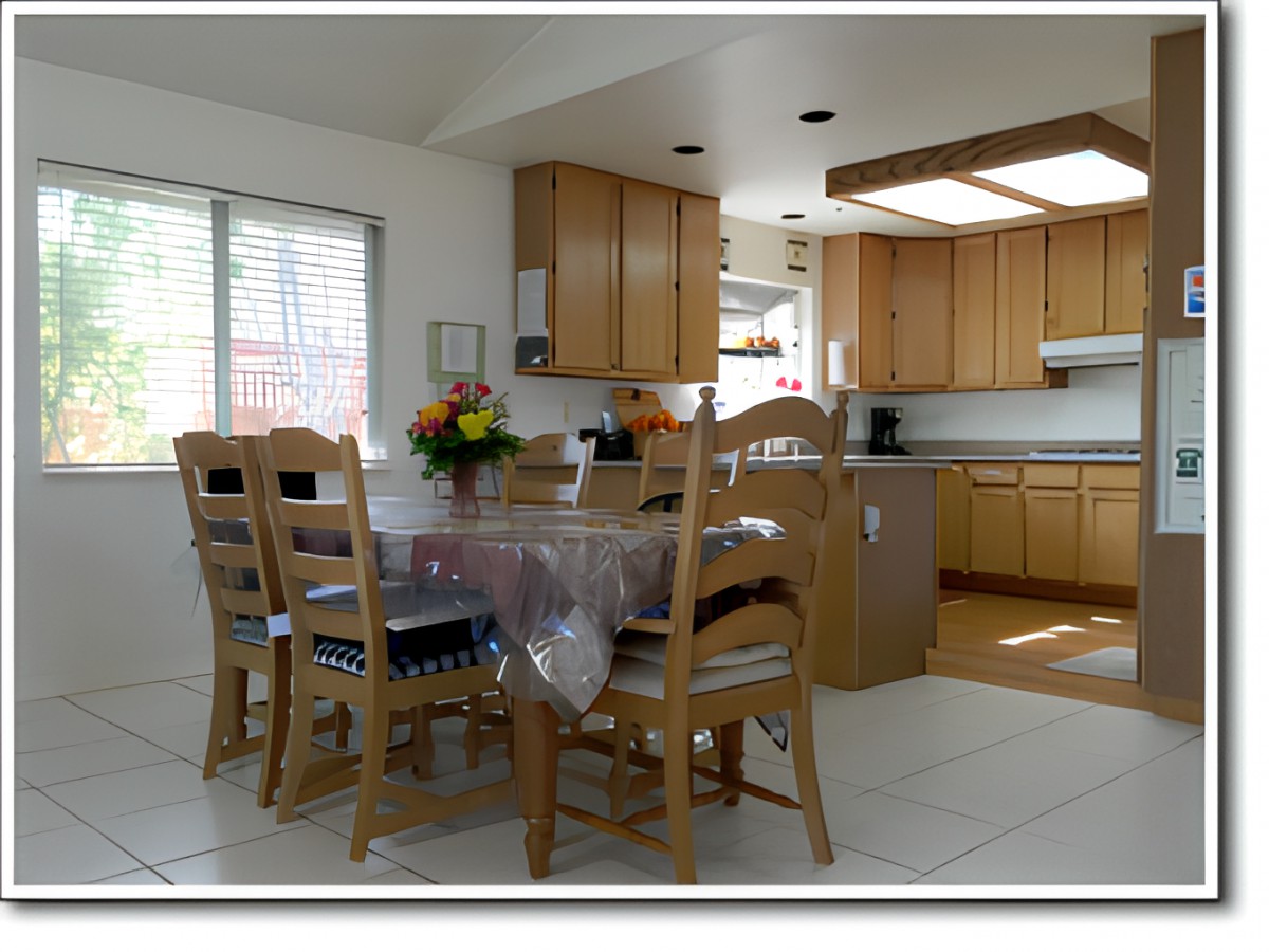 A bright kitchen with a wooden dining set and ample natural light.