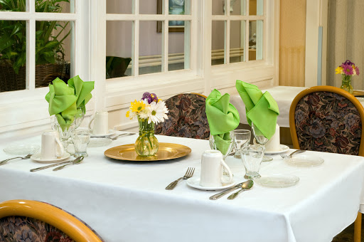 A beautifully arranged dining table with a floral centerpiece and neatly folded napkins.