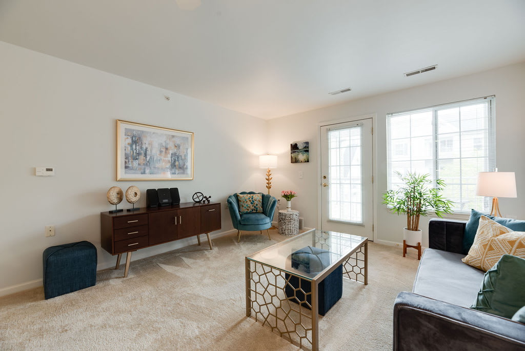 A modern living room featuring a stylish armchair, a sleek coffee table, and decorative artwork on the walls.
