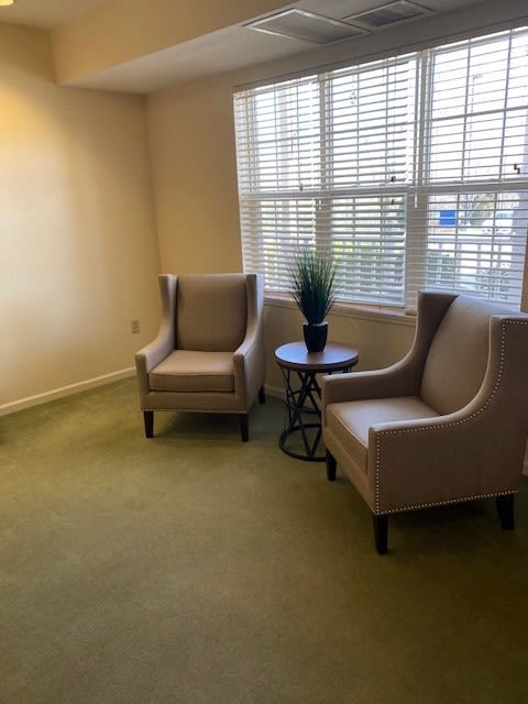 A cozy seating area with two armchairs and a small table by the window.