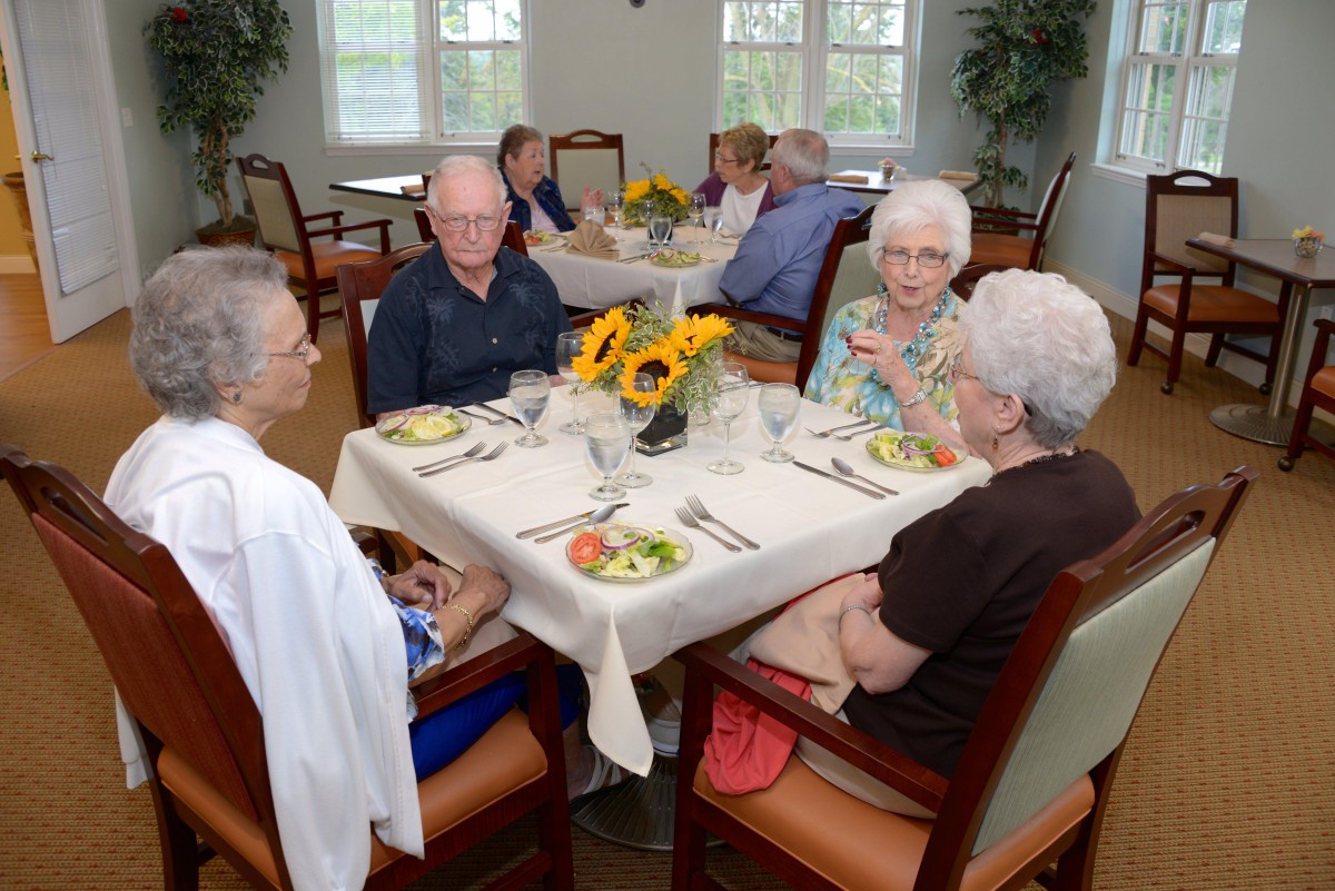 A group of seniors enjoying a meal together in a dining area.