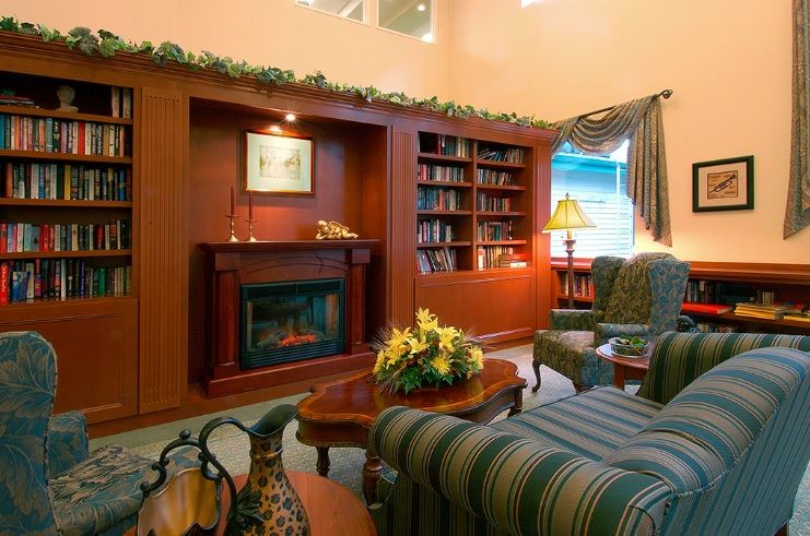A cozy living room featuring a fireplace, built-in bookshelves, and comfortable seating.