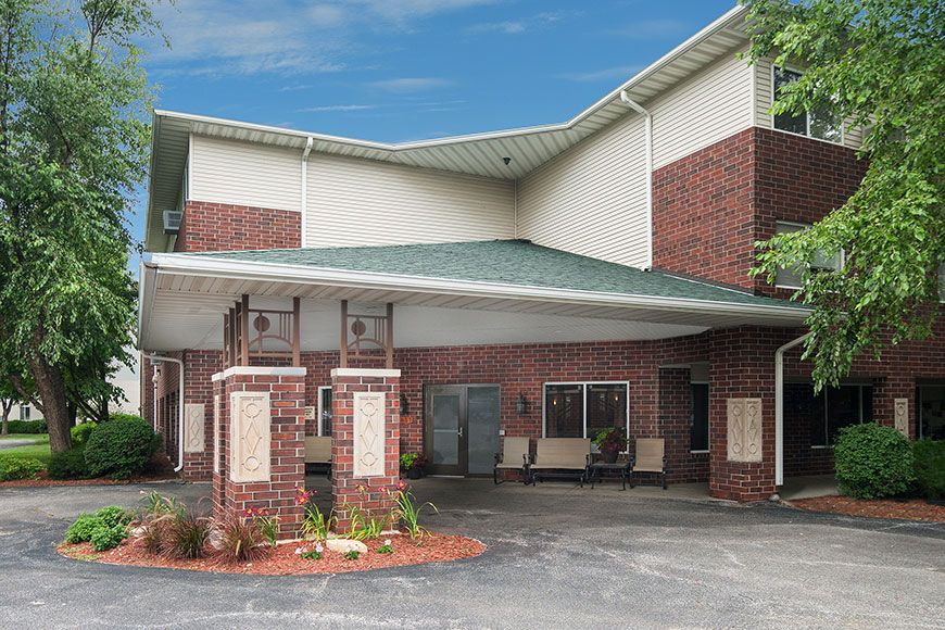 Entrance of a commercial building with a brick facade and covered driveway.
