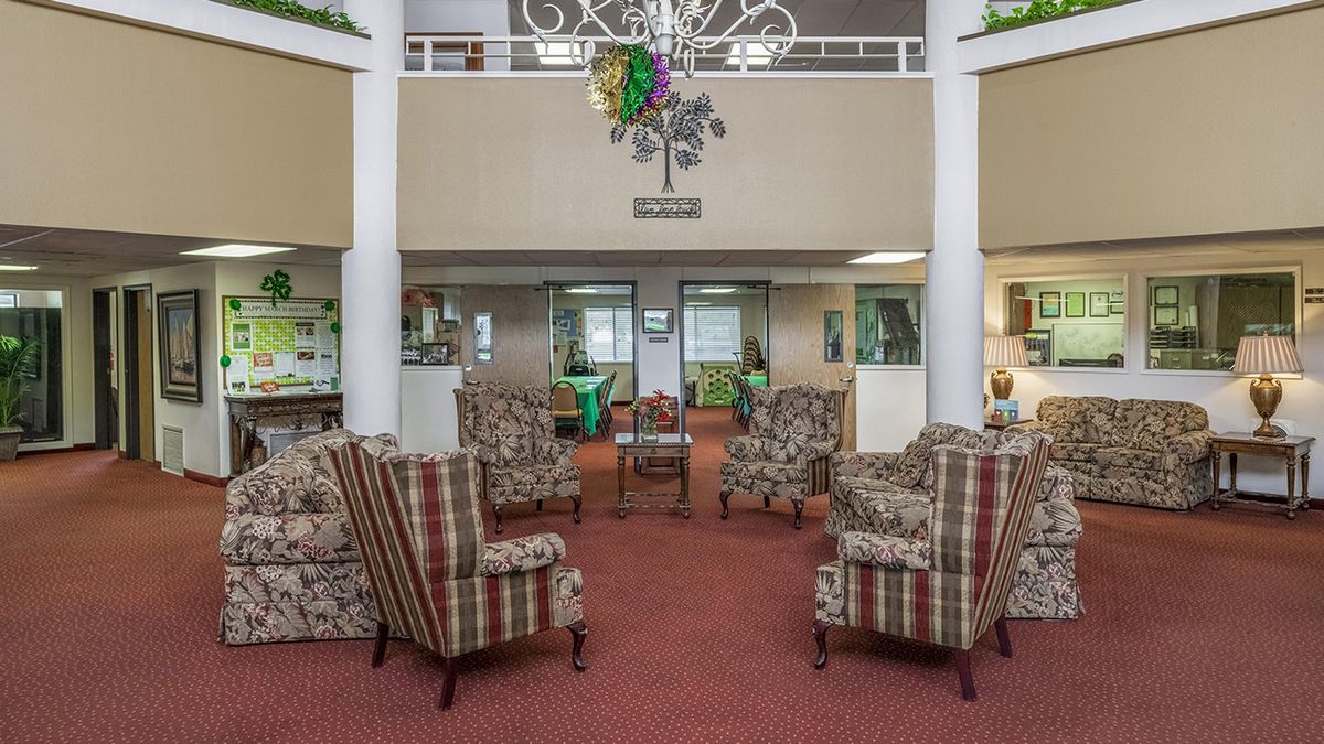 A cozy lobby area with patterned armchairs and a decorative chandelier.