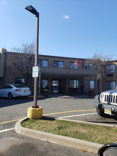 A view of a hotel building in a parking lot on a sunny day.