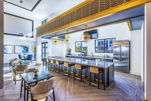 A sleek and modern kitchen featuring a bar area with stylish seating and elegant lighting.