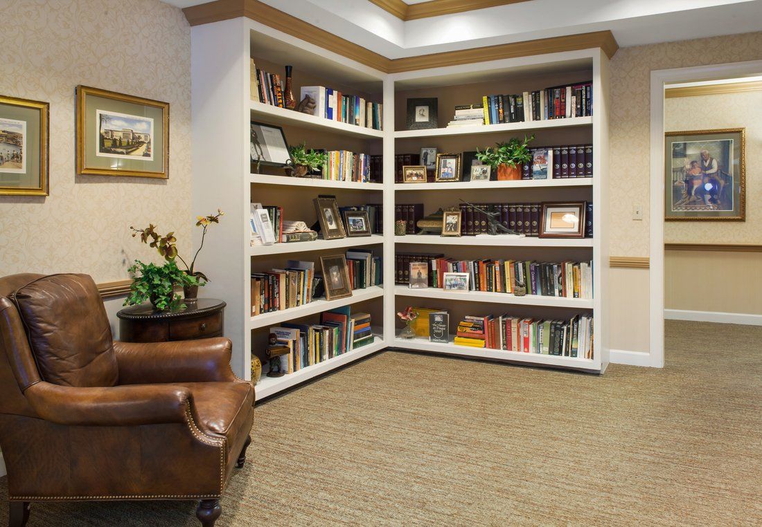 A cozy reading corner with a well-stocked bookshelf in a warmly decorated room.