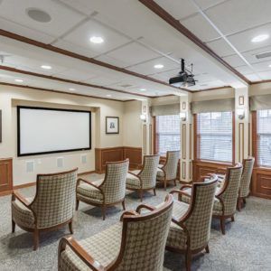 A cozy theater room with comfortable seating and a projector screen.