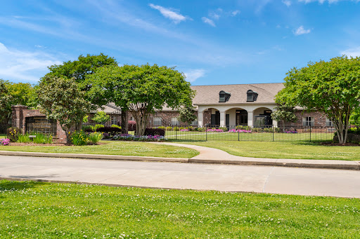 A beautiful residential property featuring well-maintained landscaping and a clear blue sky.