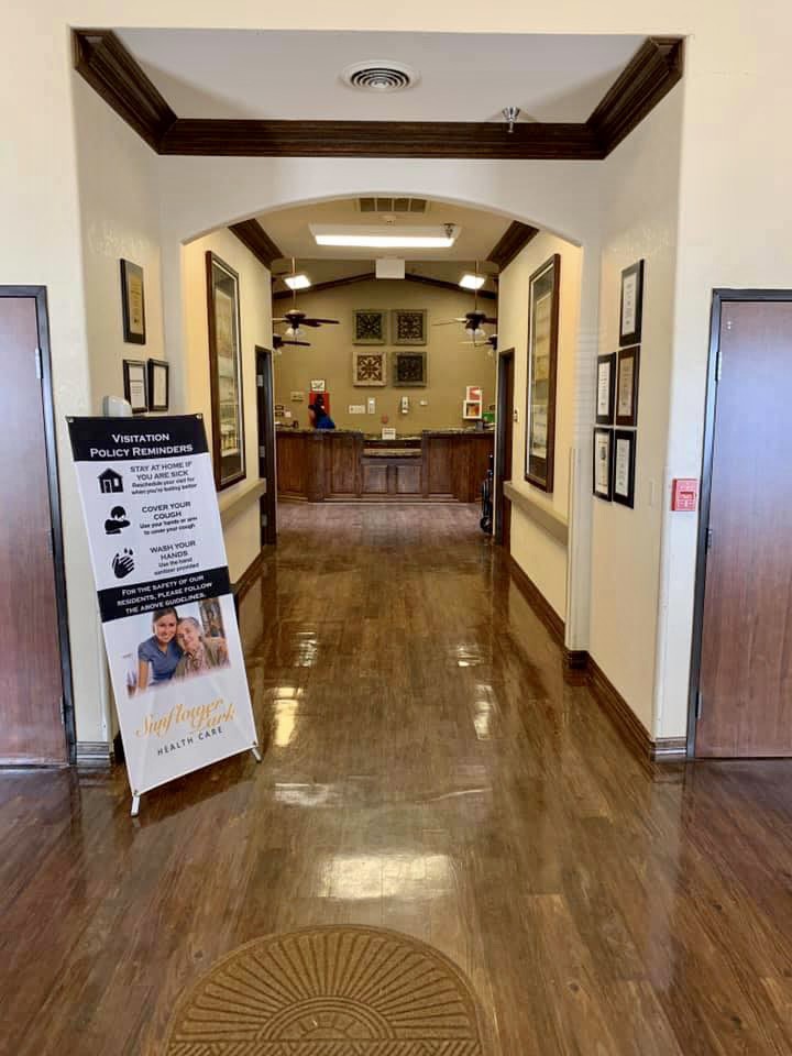 A clean and polished hallway in a building with framed decorations and informational signage.