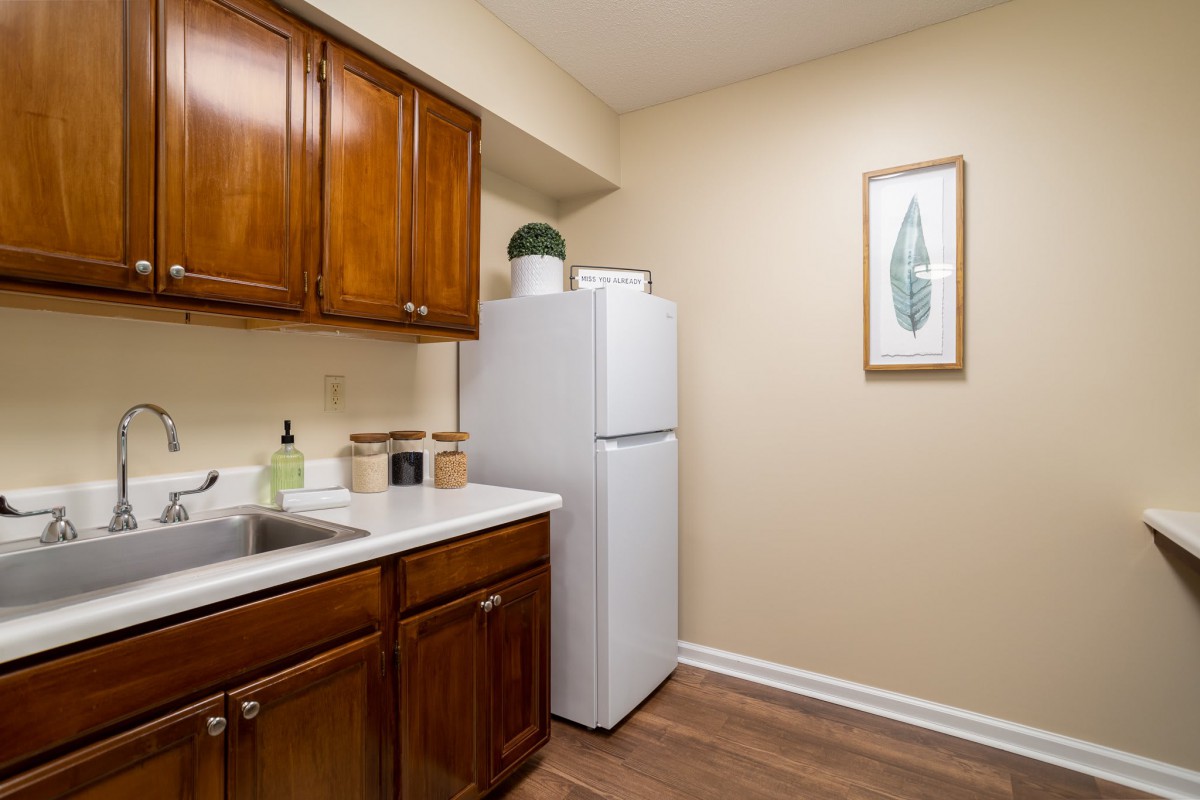 A modern kitchen featuring wooden cabinets and a white refrigerator.