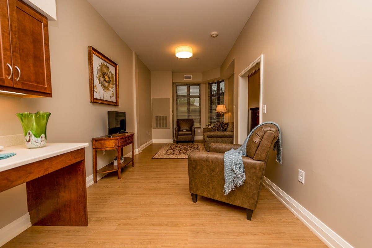 Cozy living room with armchair, television, and warm lighting.
