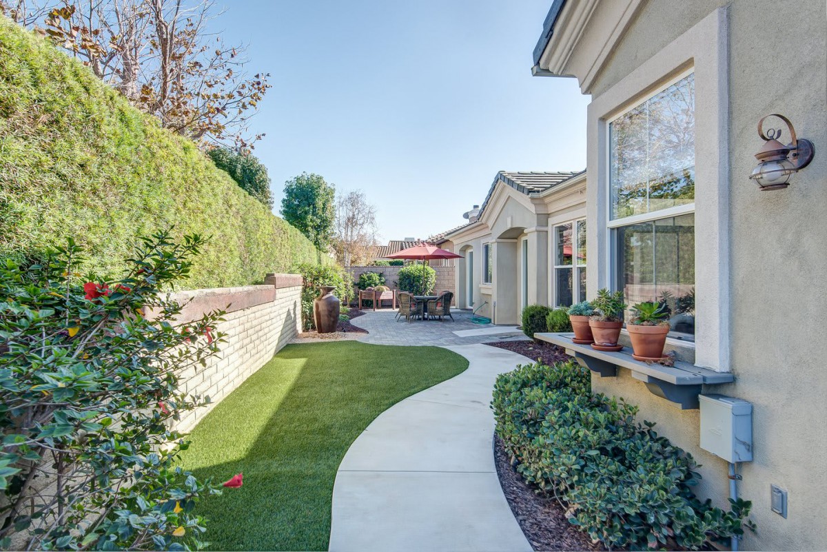 A beautifully landscaped backyard with a winding pathway and well-maintained plants.