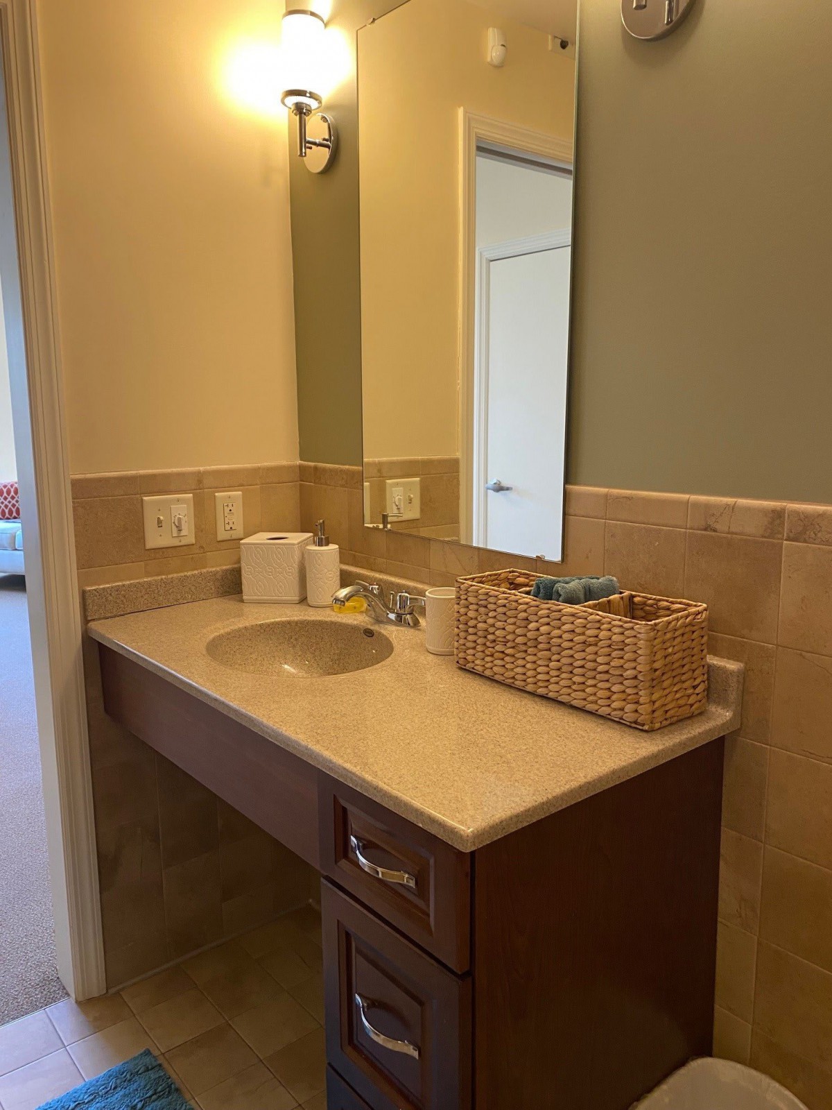 A bathroom featuring a vanity with a sink, mirror, and countertop accessories.