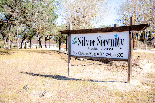 A sign displaying the name and contact information for Silver Serenity, set in a grassy outdoor area.