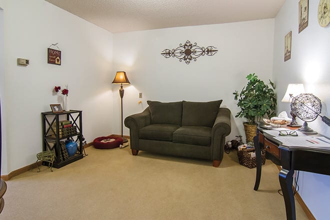 A cozy living room with a sofa, floor lamp, and decorative elements.