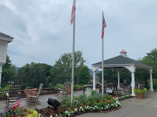A peaceful outdoor space featuring flags and well-maintained gardens near a gazebo.