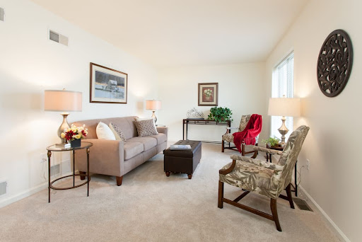 A cozy living room featuring a soft sofa, patterned armchairs, and elegant decor.