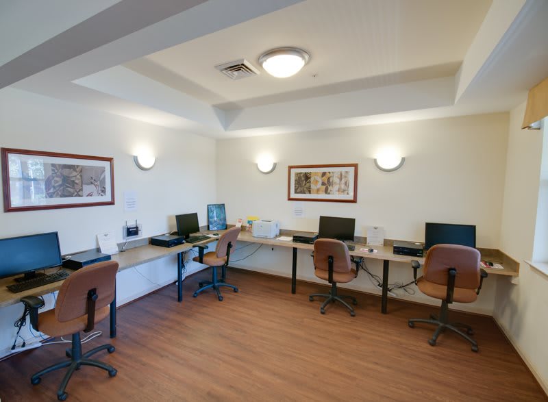 A modern office with multiple workstations equipped with computers and comfortable chairs.